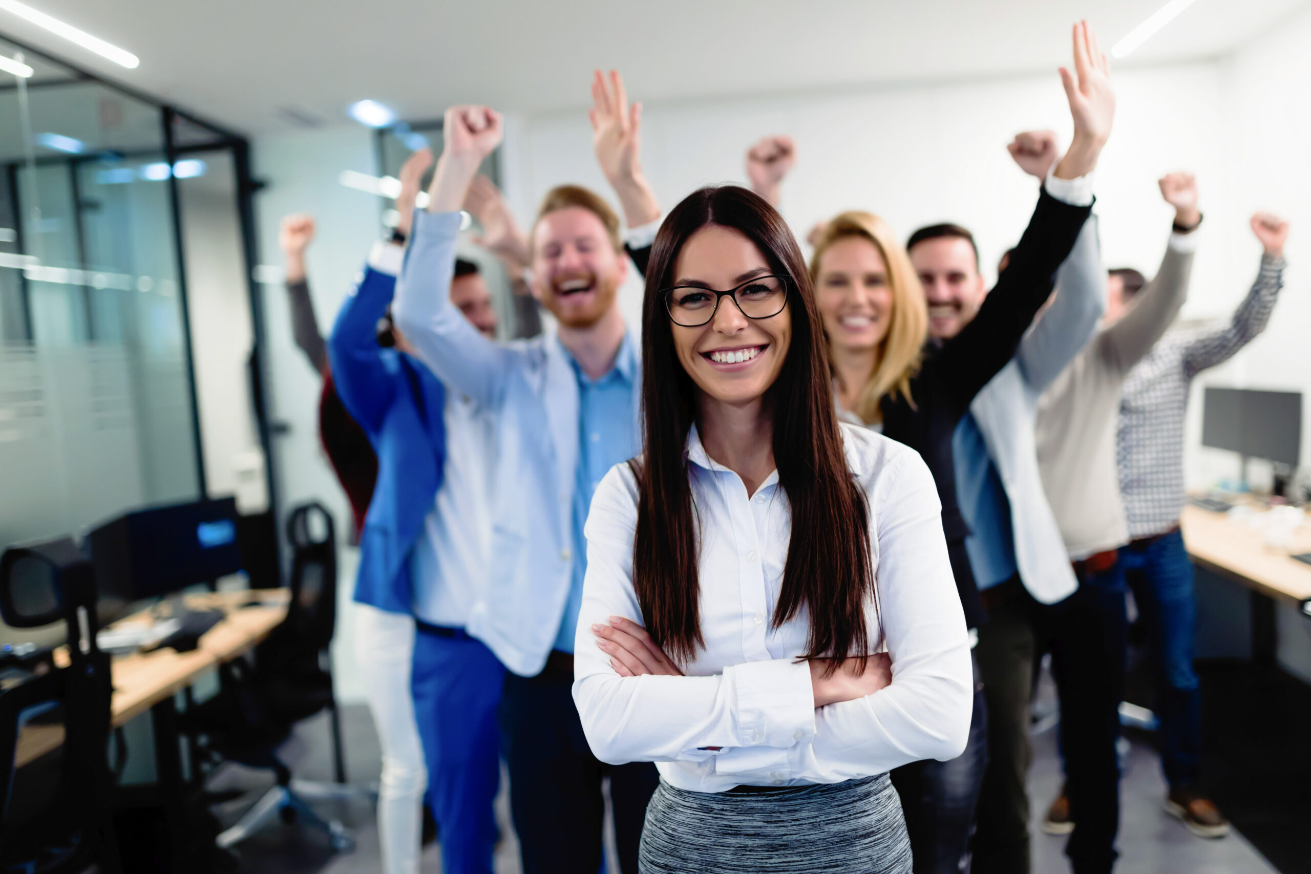 young woman standing in front of her team who are cheering