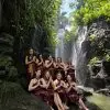 women under a waterfall at a Bali water temple