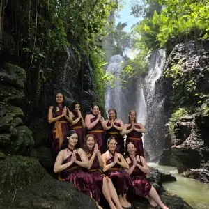 women under a waterfall at a Bali water temple