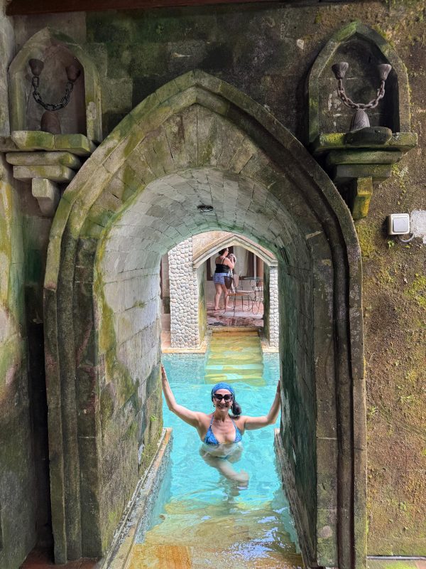 woman in the pool under arches at Retreat venue in Bali